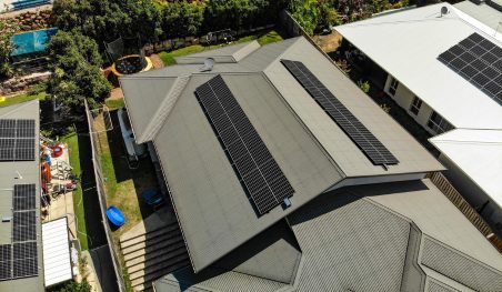 Aerial view of a home with solar panels across two roof faces
